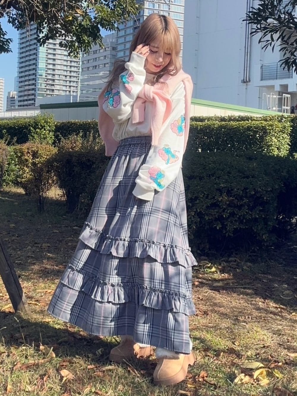 グレー系のスカート、ホワイト系のTシャツ/カットソー、ピンク系のニット/セーターを着用したレディースの秋コーディネートの3枚目の写真