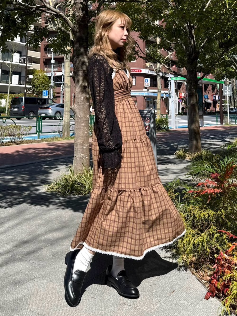 ブラウン系のワンピース、ブラック系のTシャツ/カットソーを着用したレディースの春コーディネートの2枚目の写真