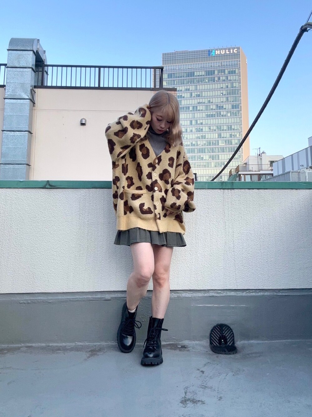 ブラウン系のカーディガン/ボレロ、グレー系のスカート、グレー系のニット/セーターを着用したレディースの秋コーディネートの2枚目の写真