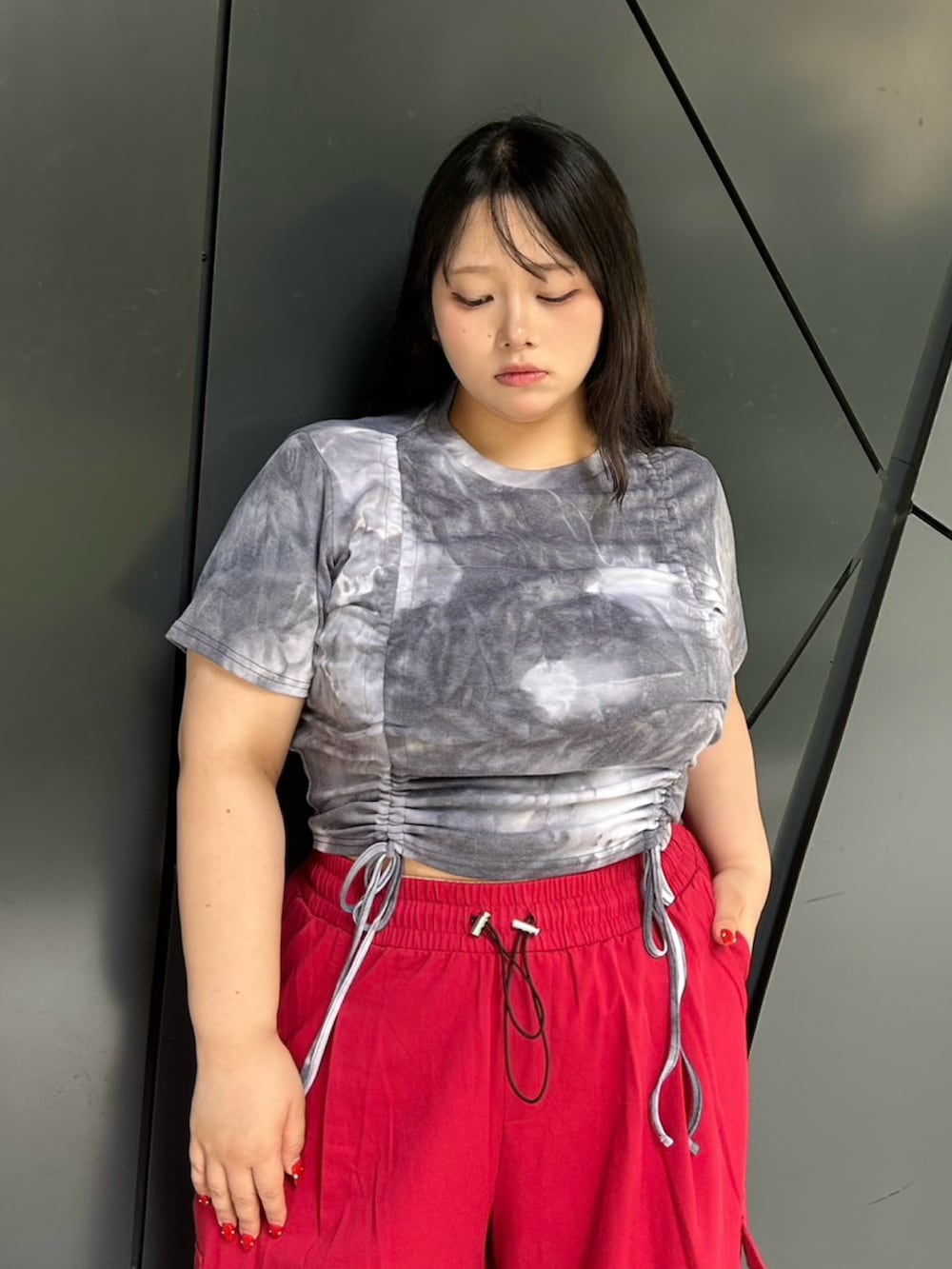 レッド系のカーゴパンツ、ブラック系のTシャツ/カットソーを着用したレディースの夏コーディネートの4枚目の写真