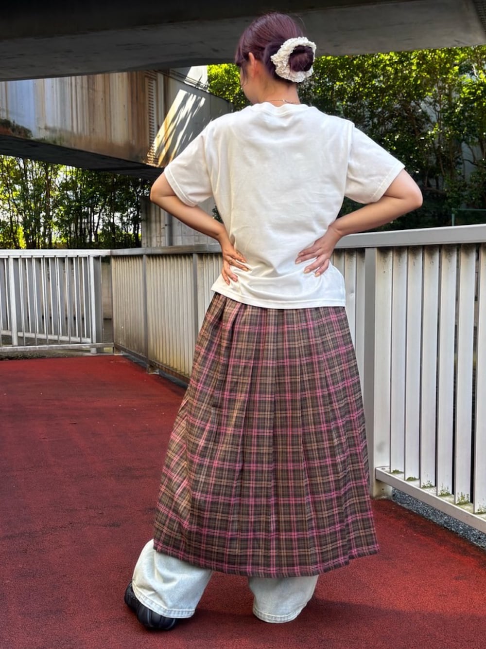 グリーン系のスカート、ホワイト系のTシャツ/カットソー、ブルー系のデニムパンツを着用したレディースの夏コーディネートの4枚目の写真