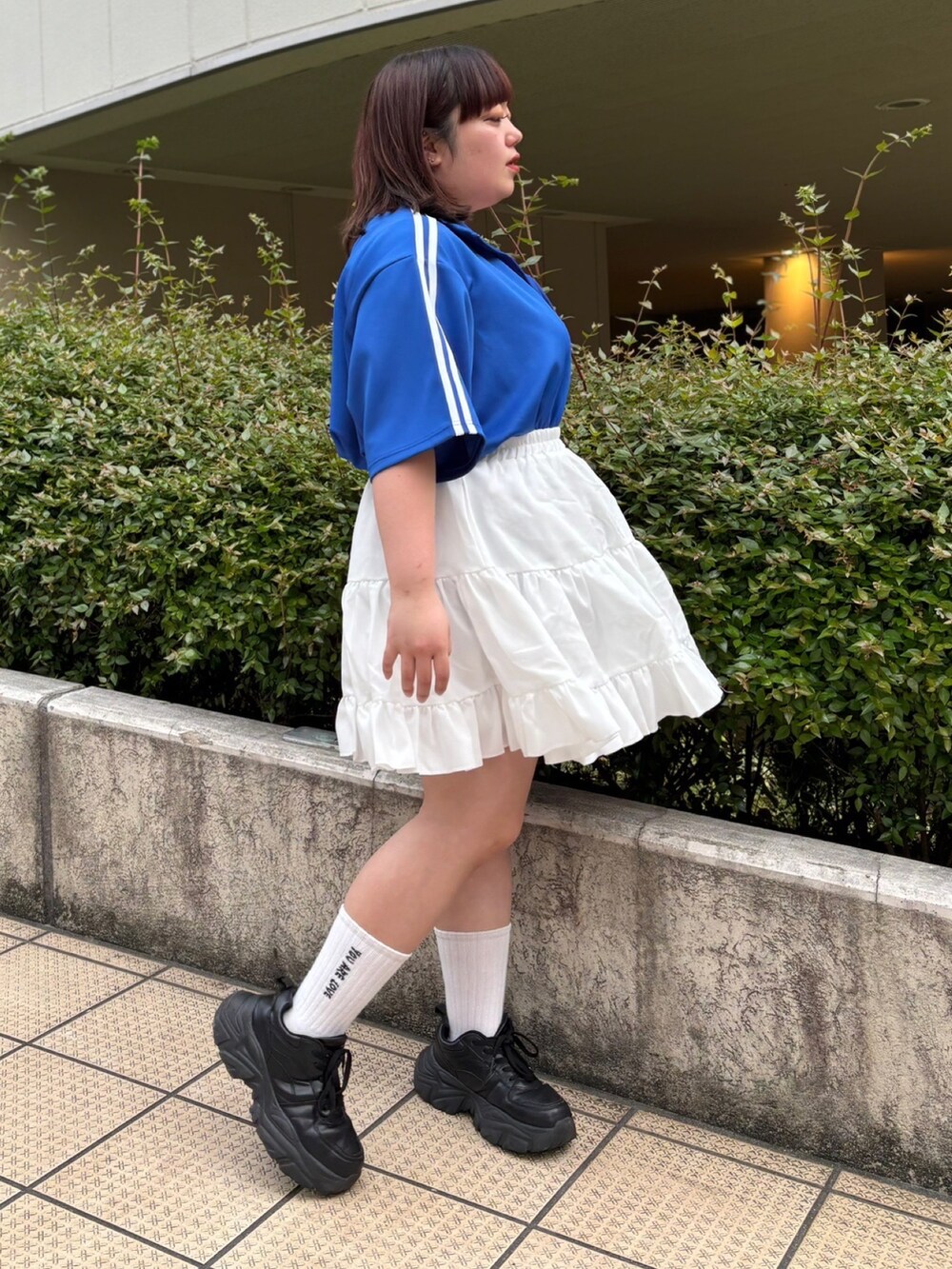 ホワイト系のスカート、ブルー系のジャージを着用したレディースの春コーディネートの3枚目の写真