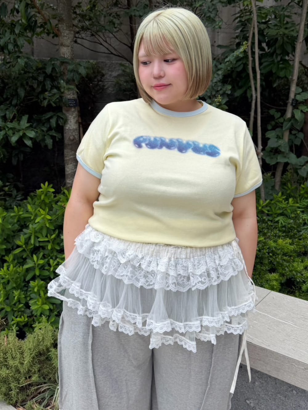 グレー系のスウェットパンツ、ホワイト系のスカート、イエロー系のTシャツ/カットソーを着用したレディースの夏コーディネートの5枚目の写真