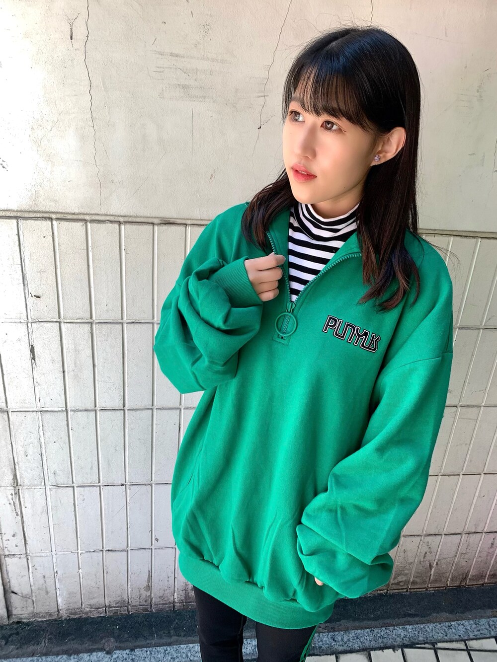 グリーン系のスウェット、ホワイト系のスニーカー、ホワイト系のTシャツ/カットソーを着用したレディースの秋コーディネートの2枚目の写真