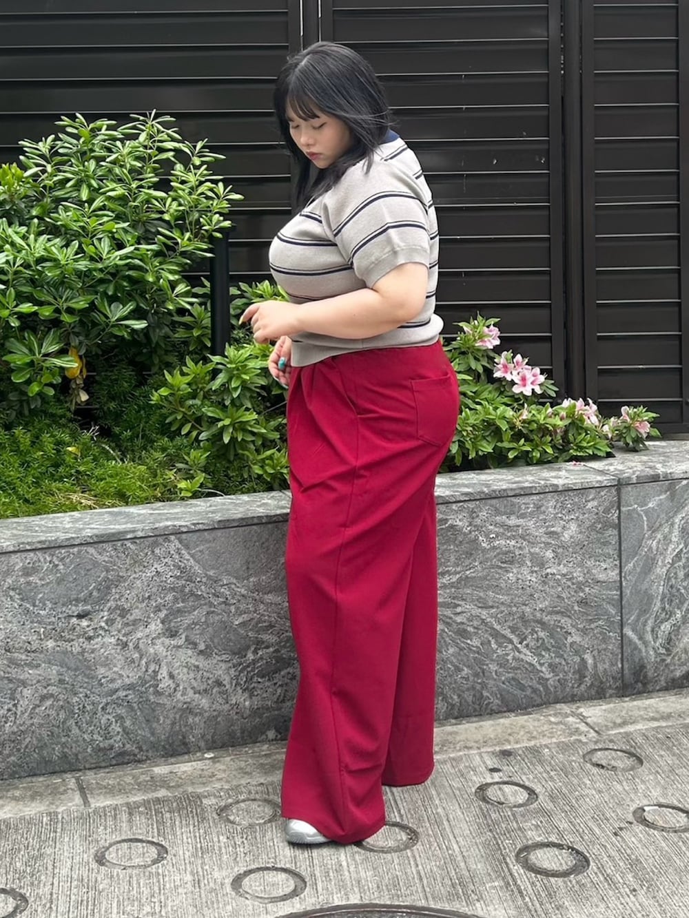 レッド系のその他パンツ、グレー系のポロシャツを着用したレディースの春コーディネートの3枚目の写真