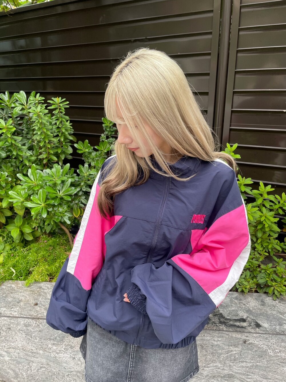 ブルー系のナイロンジャケット、ブラック系のデニムスカートを着用したレディースの秋コーディネートの5枚目の写真