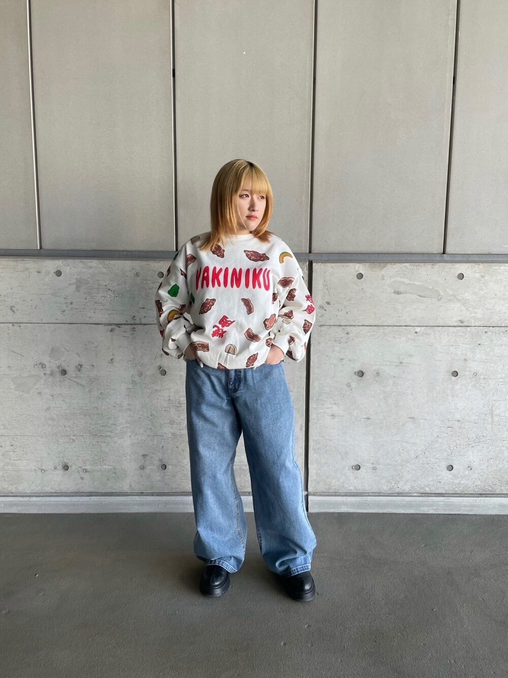 レッド系のスウェット、ブルー系のデニムパンツを着用したレディースの冬コーディネートの2枚目の写真