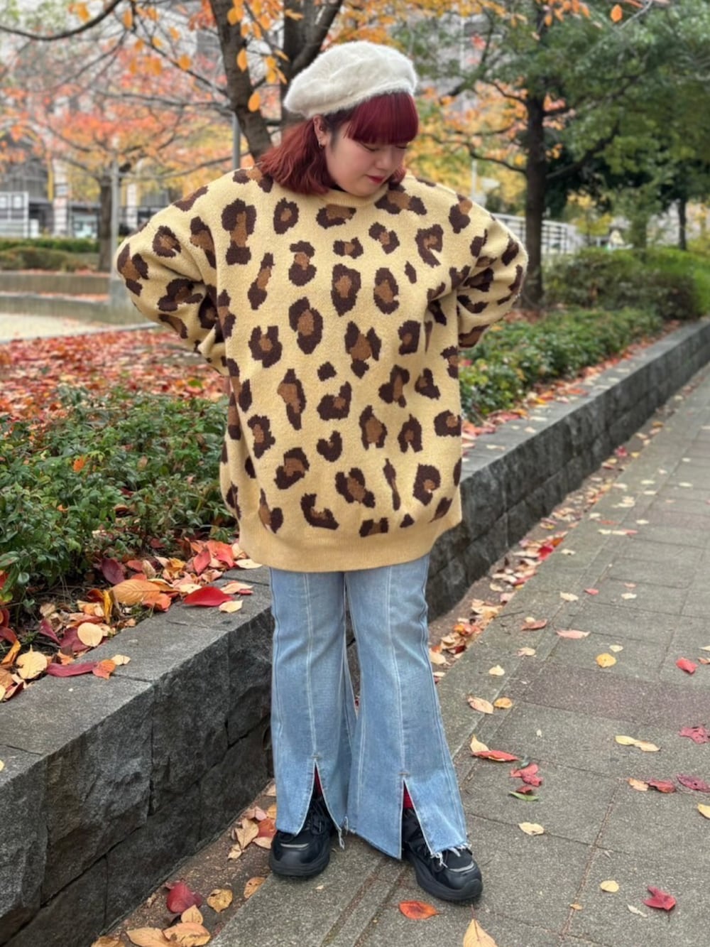 ブラウン系のニット/セーター、ブルー系のデニムパンツ、ホワイト系のハンチング/ベレー帽を着用したレディースの冬コーディネートの2枚目の写真