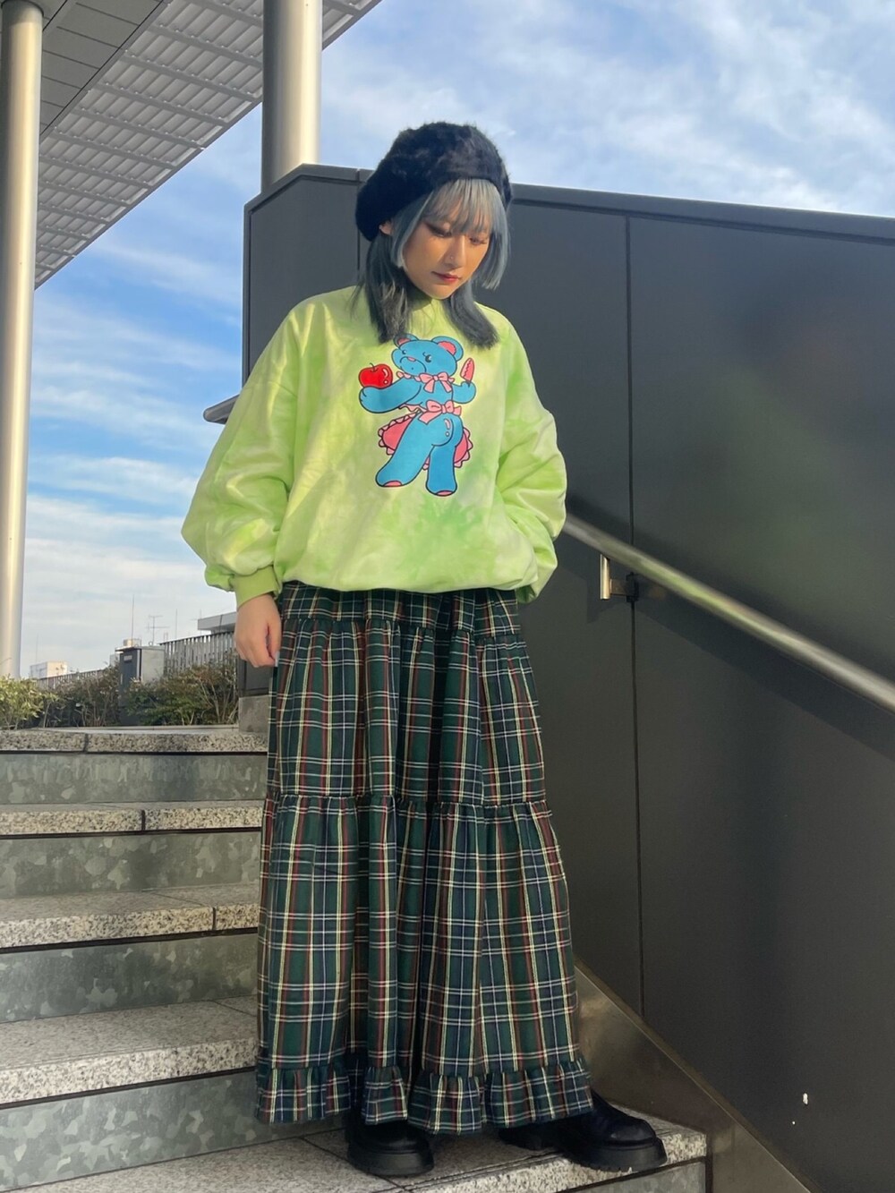 グリーン系のスカート、グリーン系のスウェットを着用したレディースの冬コーディネートの2枚目の写真