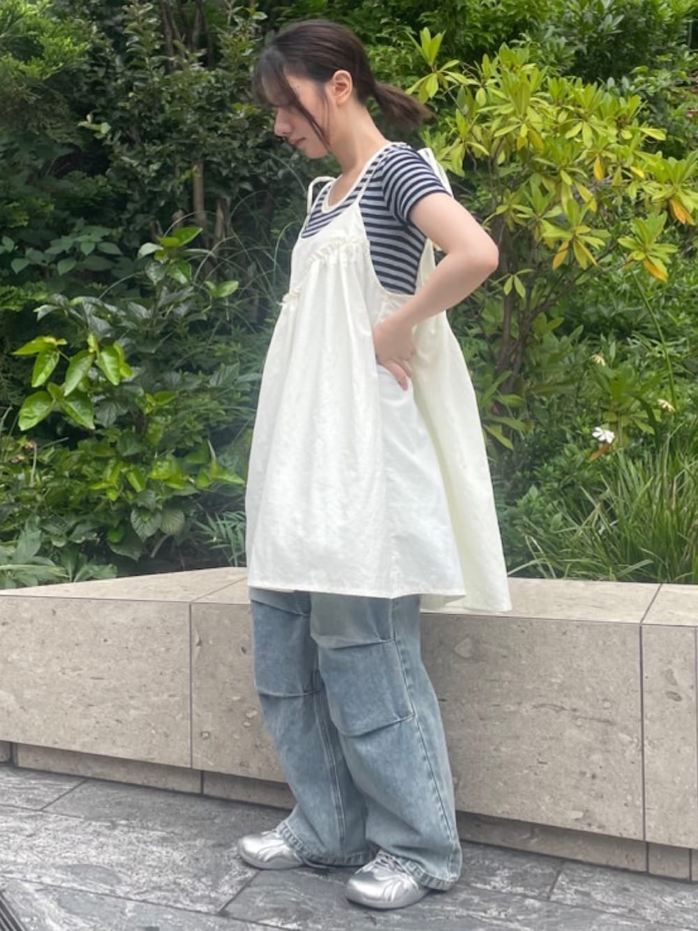 ブルー系のデニムパンツ、ホワイト系のワンピース、ブルー系のTシャツ/カットソーを着用したレディースの夏コーディネートの3枚目の写真