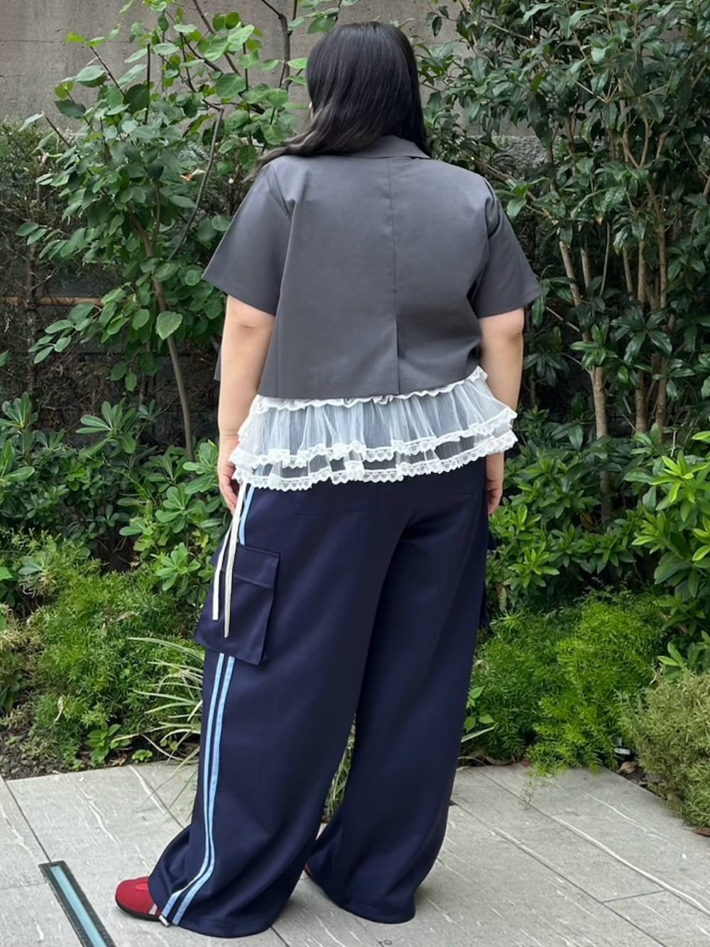 ブルー系のカーゴパンツ、グレー系のテーラードジャケット、ホワイト系のスカートを着用したレディースの夏コーディネートの4枚目の写真
