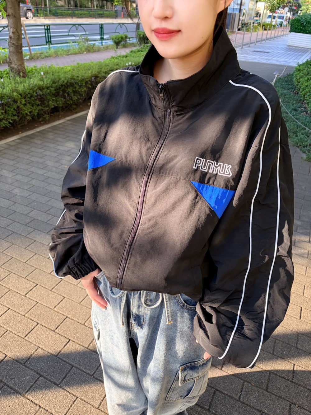 ブルー系のデニムパンツ、ブラック系のナイロンジャケットを着用したレディースの秋コーディネートの6枚目の写真