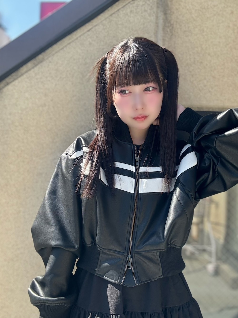 ブラック系のスカート、ブラック系のブルゾンを着用したレディースの春コーディネートの4枚目の写真