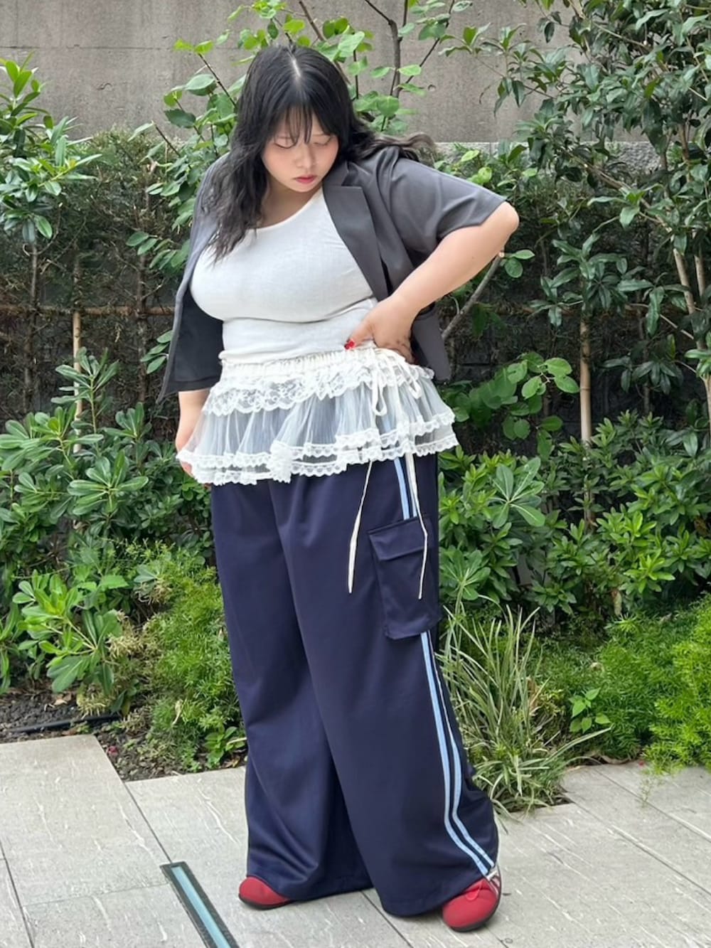 ブルー系のカーゴパンツ、グレー系のテーラードジャケット、ホワイト系のスカートを着用したレディースの夏コーディネートの3枚目の写真