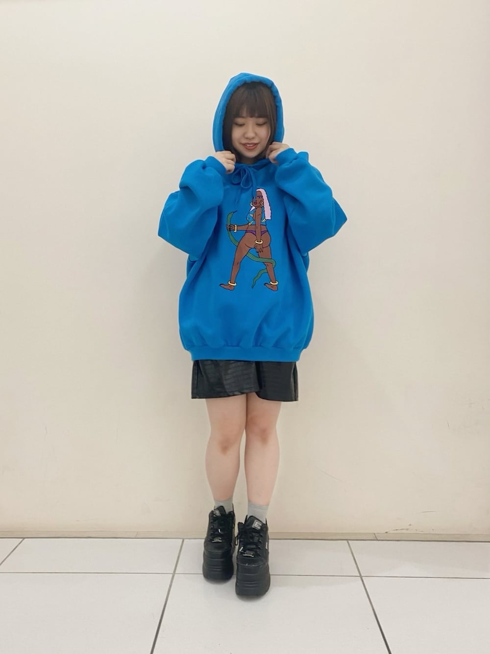 ブルー系のパーカー、ブラック系のスカートを着用したレディースの冬コーディネートの2枚目の写真