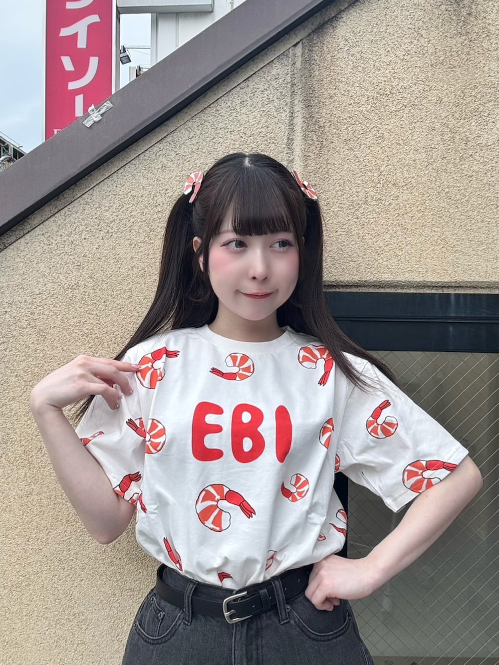 ブラック系のデニムパンツ、レッド系のTシャツ/カットソー、ブラック系のベルトを着用したレディースの春コーディネートの5枚目の写真