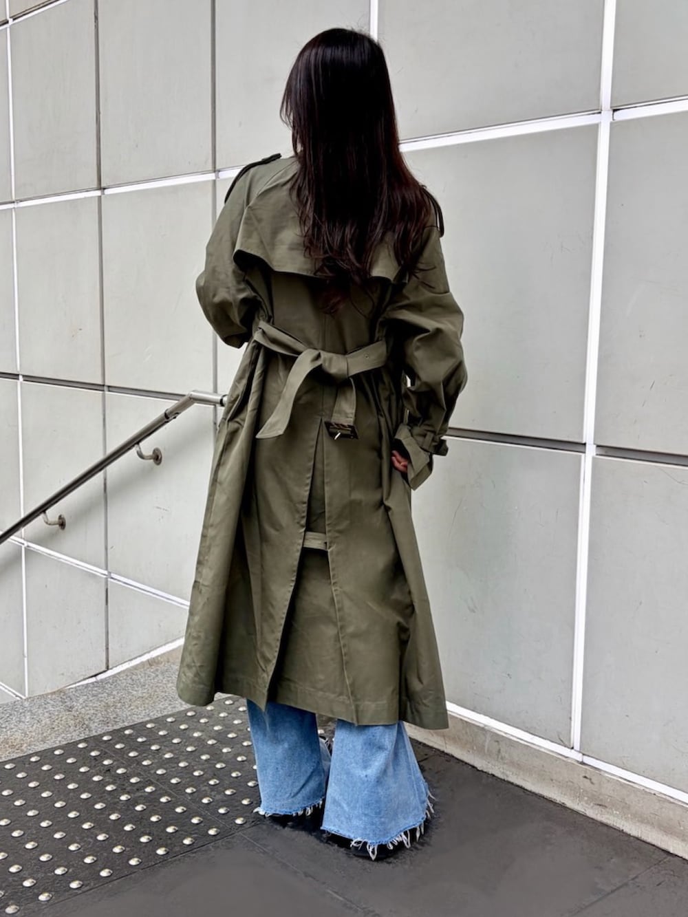 グリーン系のトレンチコート、ブルー系のデニムパンツ、ホワイト系のTシャツ/カットソーを着用したレディースの春コーディネートの6枚目の写真