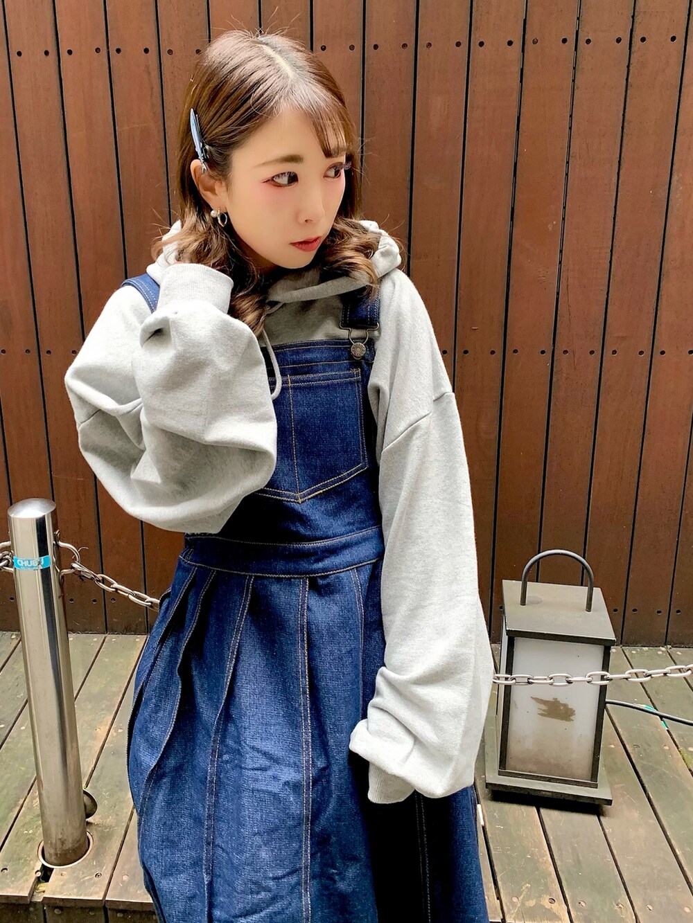 ブルー系のジャンパースカート、グレー系のパーカーを着用したレディースの秋コーディネートの3枚目の写真