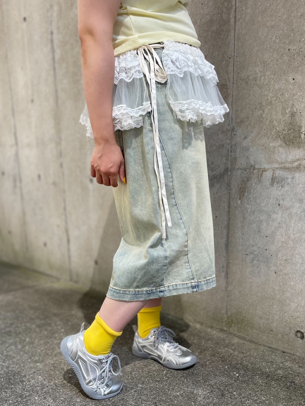 ブルー系のデニムパンツ、ホワイト系のスカート、イエロー系のTシャツ/カットソーを着用したレディースの夏コーディネートの6枚目の写真