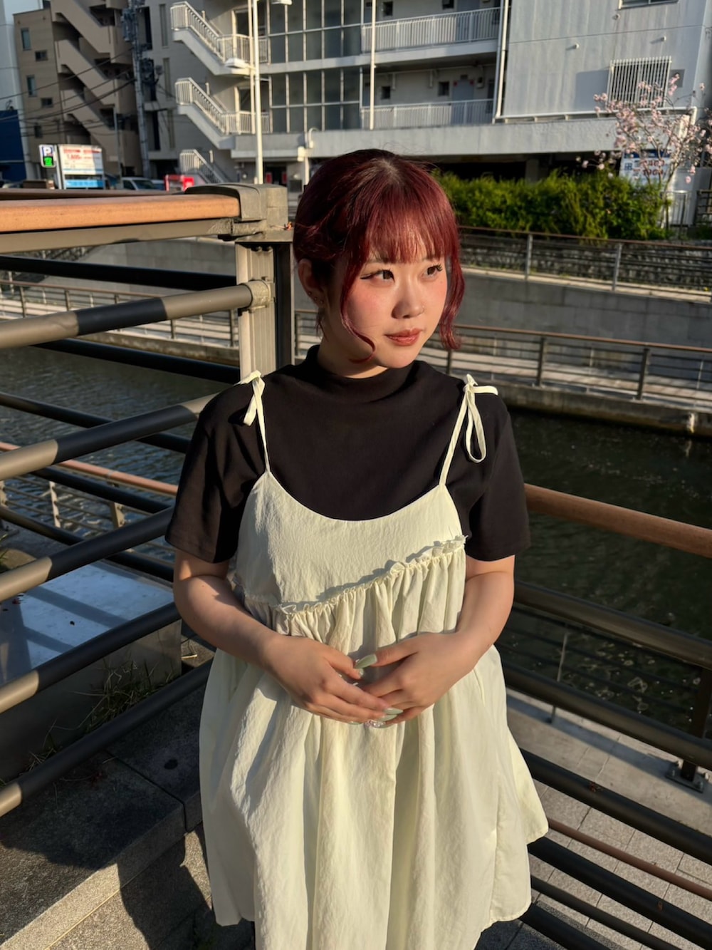 ブラック系のデニムパンツ、ホワイト系のワンピース、ブラック系のTシャツ/カットソーを着用したレディースの春コーディネートの5枚目の写真