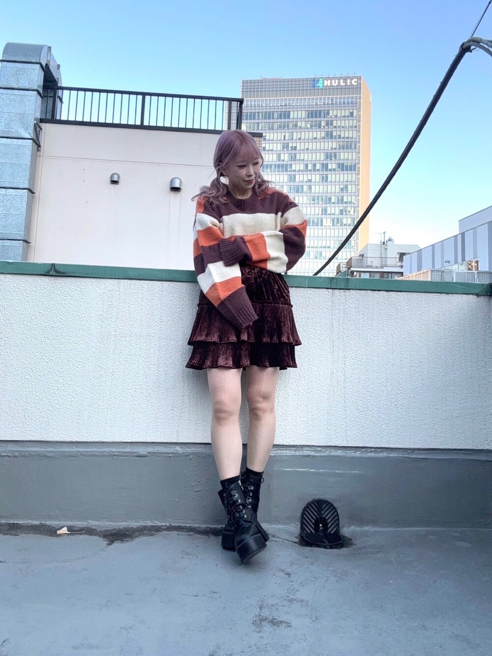 ブラウン系のニット/セーター、ブラウン系のスカートを着用したレディースの冬コーディネートの2枚目の写真