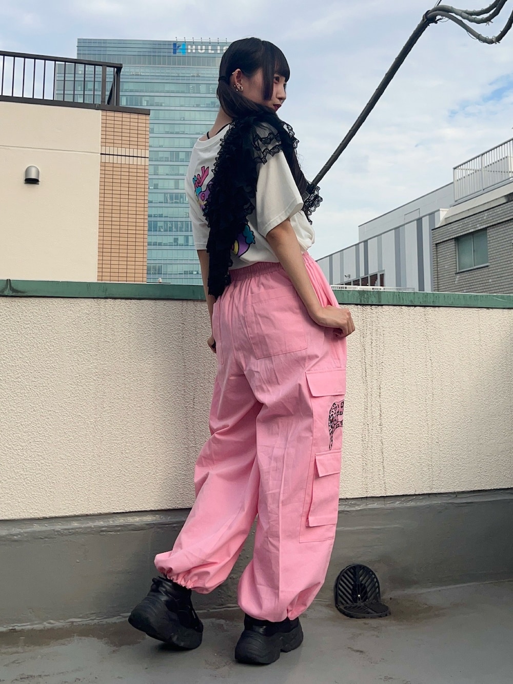 ピンク系のカーゴパンツ、ブラック系のスカート、ホワイト系のTシャツ/カットソーを着用したレディースの秋コーディネートの3枚目の写真