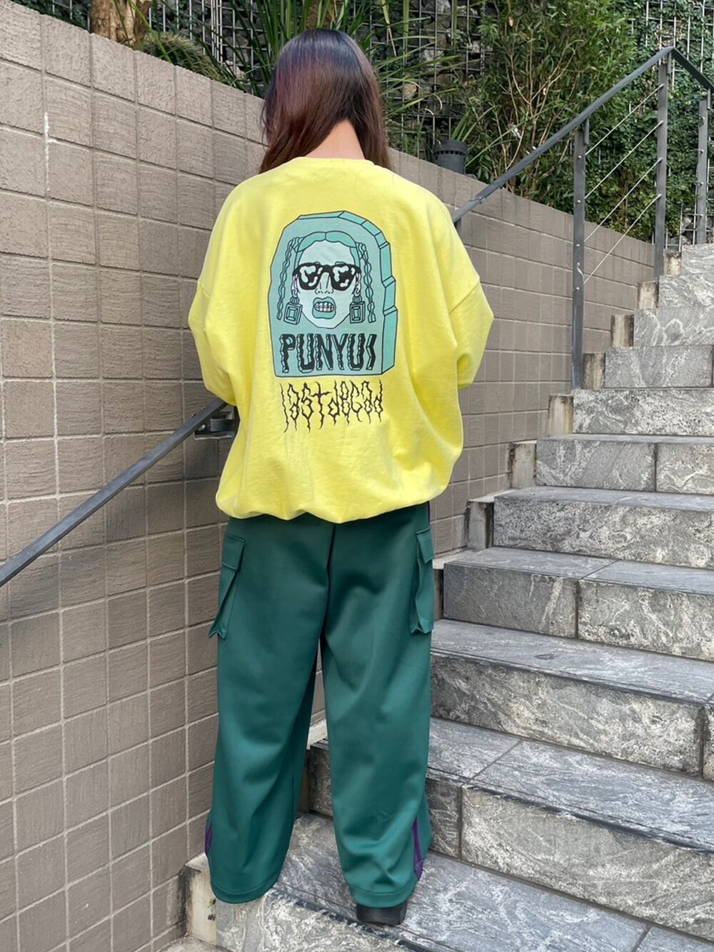 イエロー系のスウェット、グリーン系のカーゴパンツを着用したレディースの冬コーディネートの3枚目の写真