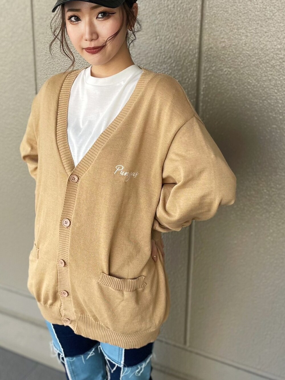 ホワイト系のTシャツ/カットソー、ベージュ系のカーディガン/ボレロ、ブルー系のデニムパンツを着用したレディースの春コーディネートの2枚目の写真