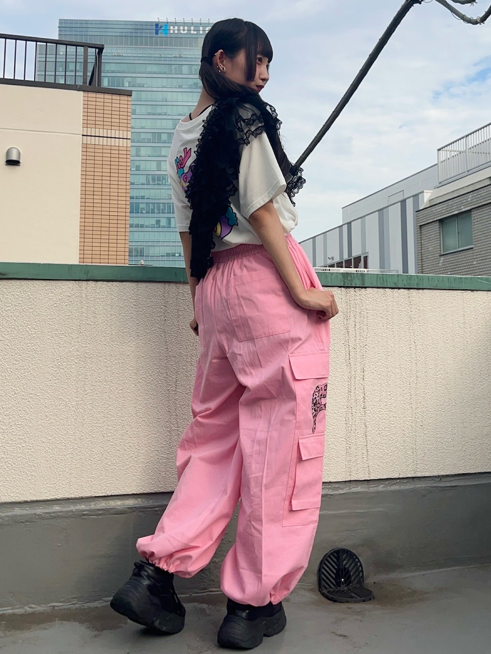 ピンク系のカーゴパンツ、ブラック系のスカート、ホワイト系のTシャツ/カットソーを着用したレディースの秋コーディネートの6枚目の写真