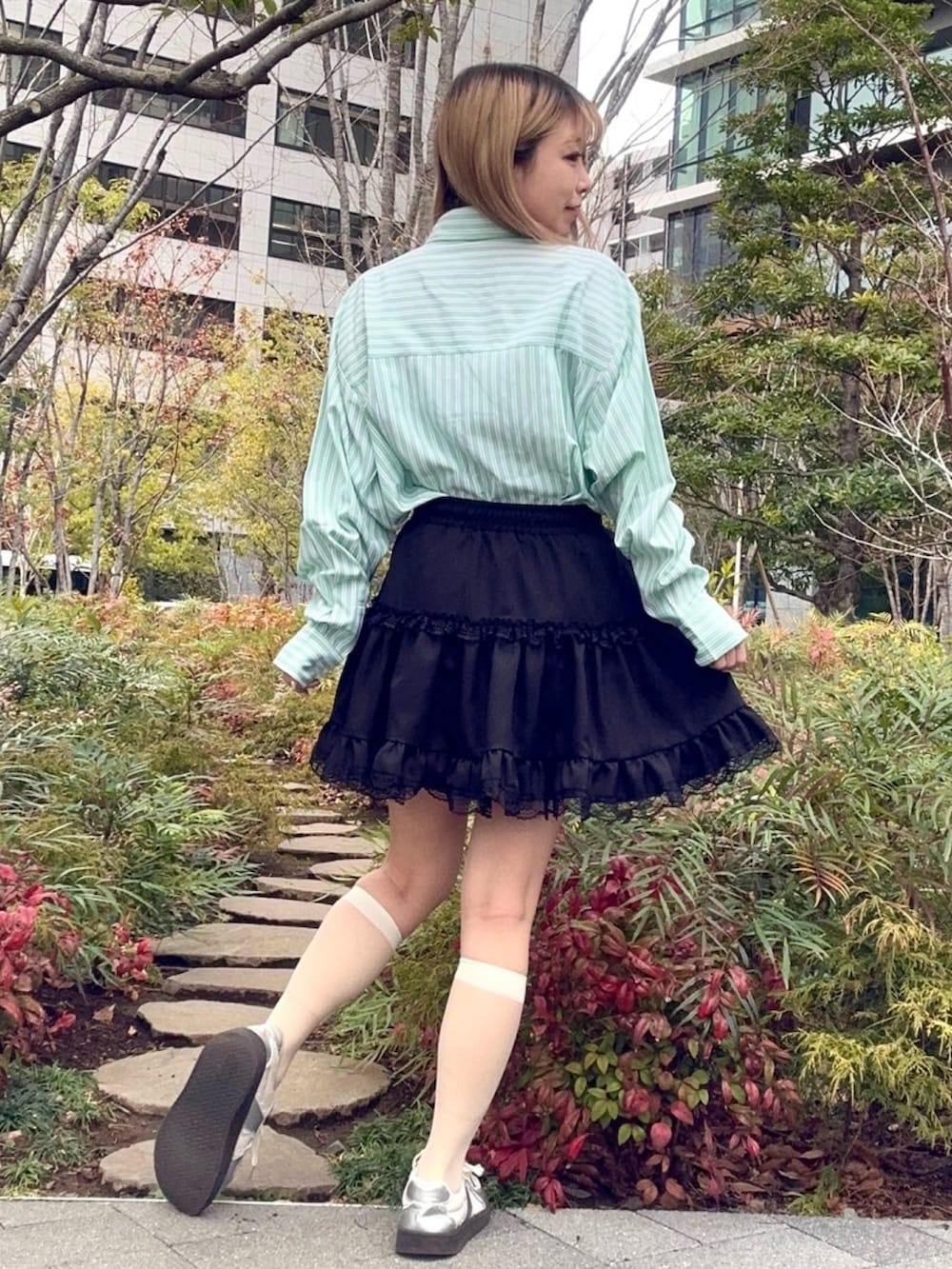 ブラック系のスカート、グリーン系のシャツ/ブラウスを着用したレディースの冬コーディネートの3枚目の写真