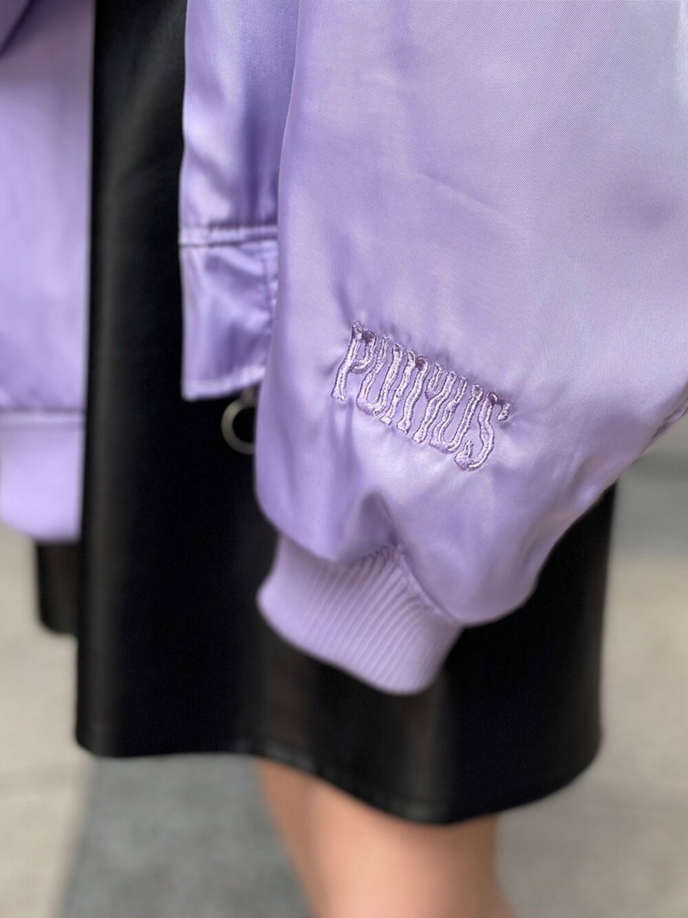 ホワイト系のTシャツ/カットソー、ブラック系のジャンパースカート、パープル系のMA-1を着用したレディースの冬コーディネートの3枚目の写真