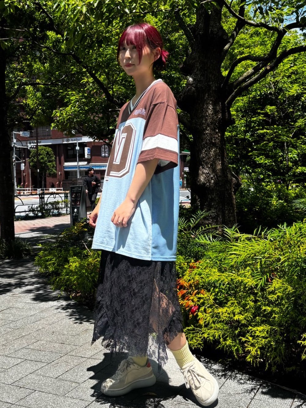 ブラウン系のTシャツ/カットソー、ブラック系のスカート、ブルー系のデニムパンツを着用したレディースの夏コーディネートの3枚目の写真