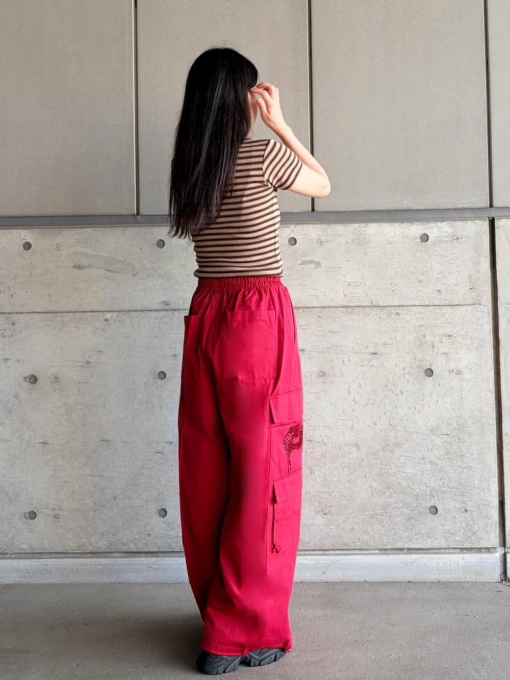 レッド系のカーゴパンツ、ブラウン系のTシャツ/カットソーを着用したレディースの夏コーディネートの7枚目の写真