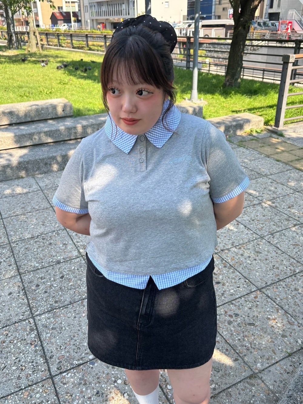 ブラック系のデニムスカート、グレー系のTシャツ/カットソーを着用したレディースの夏コーディネートの2枚目の写真