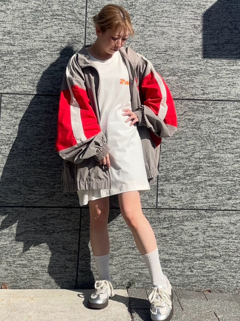 グレー系のナイロンジャケット、ホワイト系のTシャツ/カットソーを着用したレディースの春コーディネートの2枚目の写真