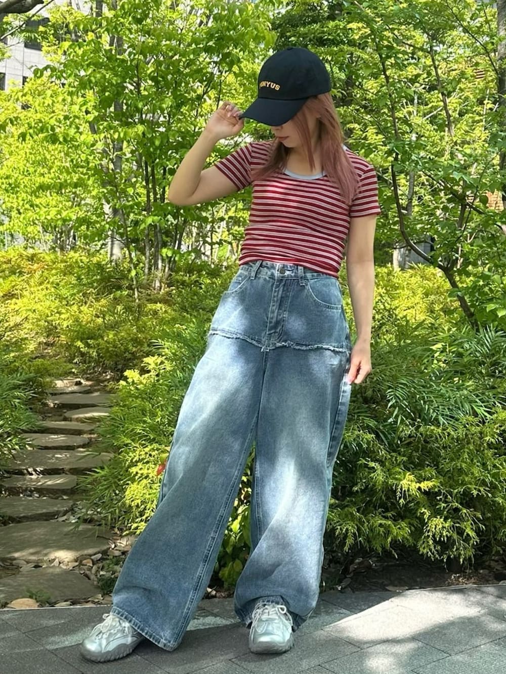 ブルー系のデニムパンツ、レッド系のTシャツ/カットソー、ブルー系のキャップを着用したレディースの春コーディネートの5枚目の写真
