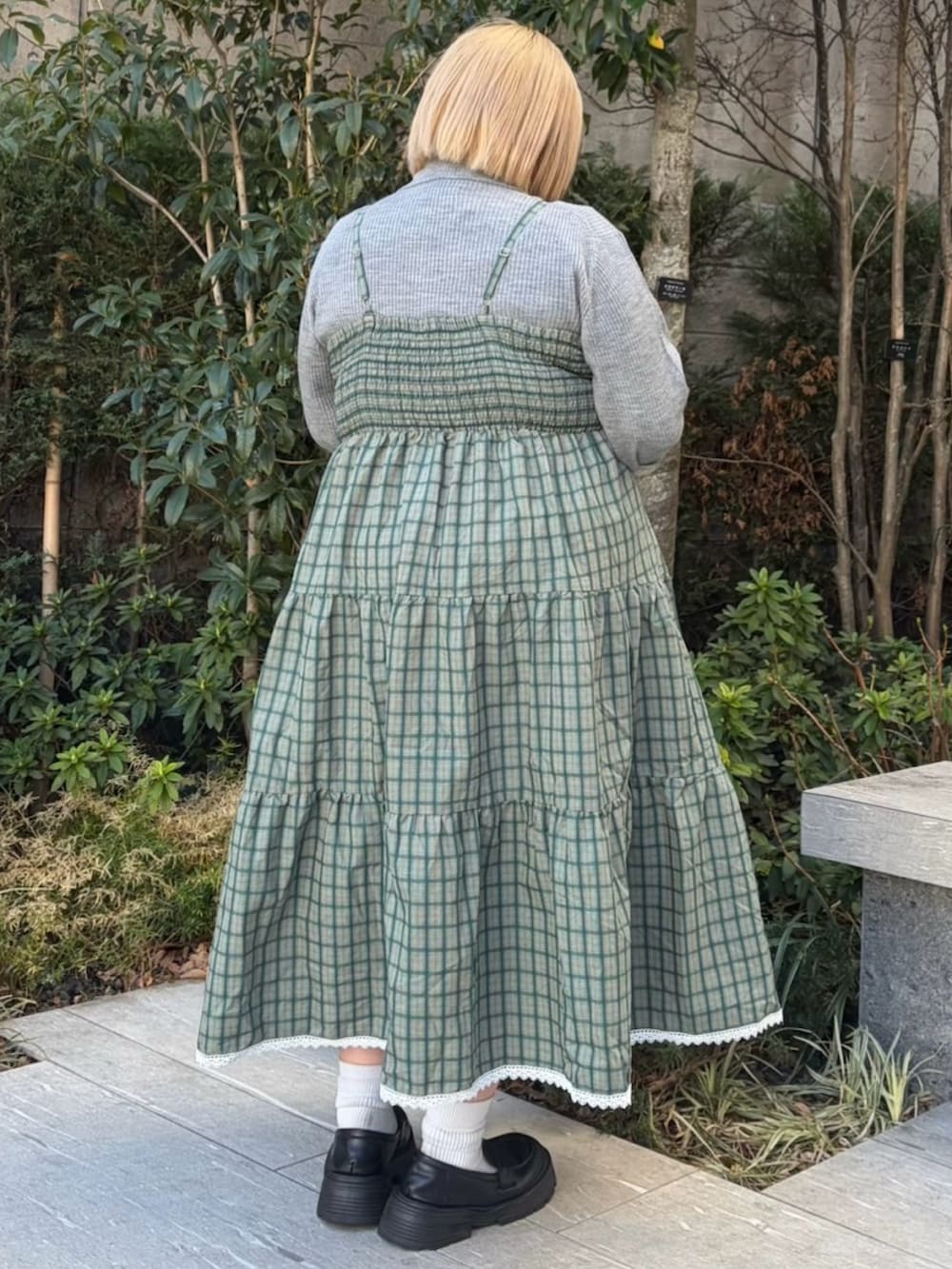 グリーン系のワンピース、グレー系のニット/セーターを着用したレディースの春コーディネートの4枚目の写真