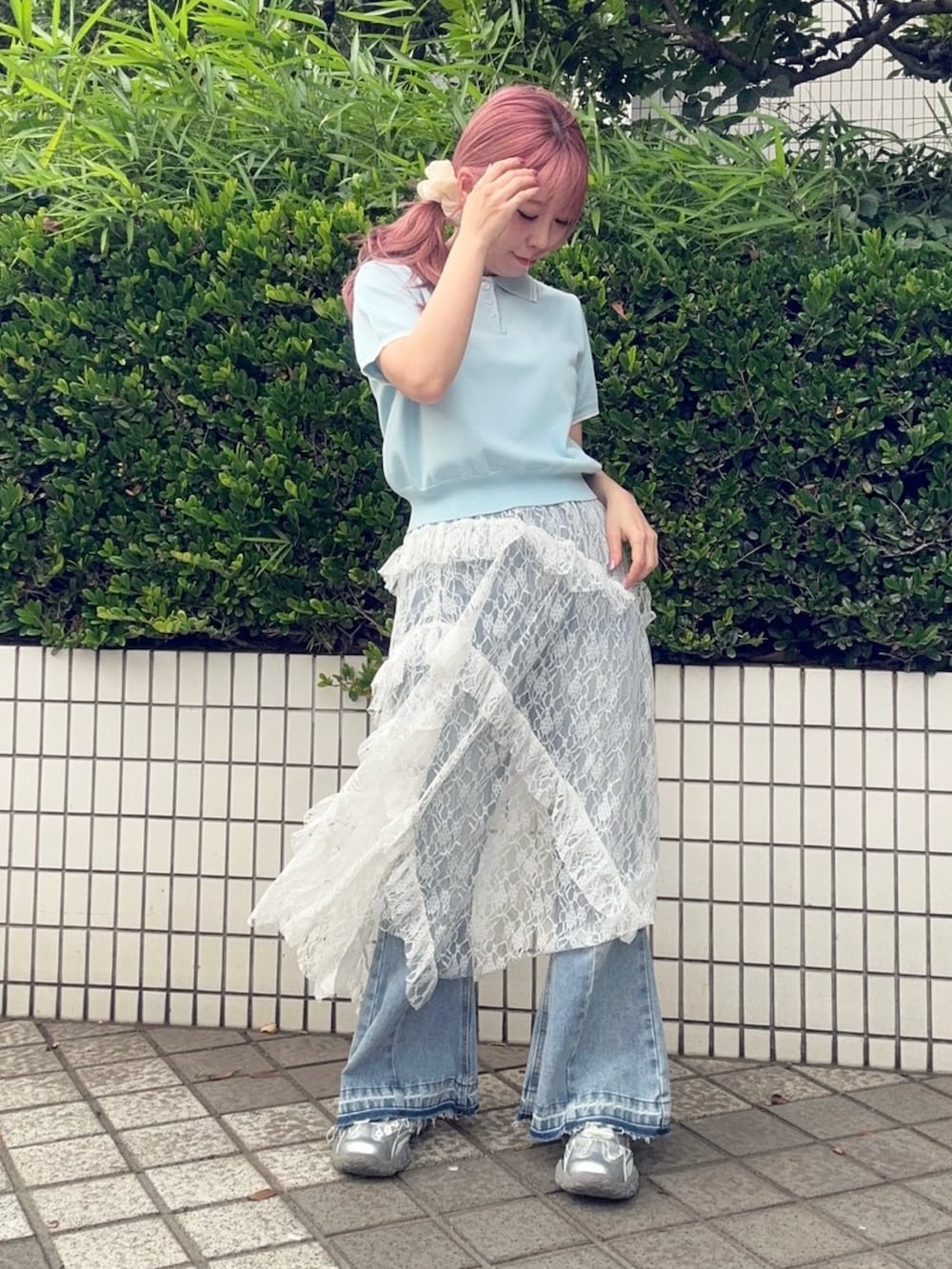 ホワイト系のスカート、ブルー系のポロシャツ、ブルー系のデニムパンツを着用したレディースの夏コーディネートの2枚目の写真