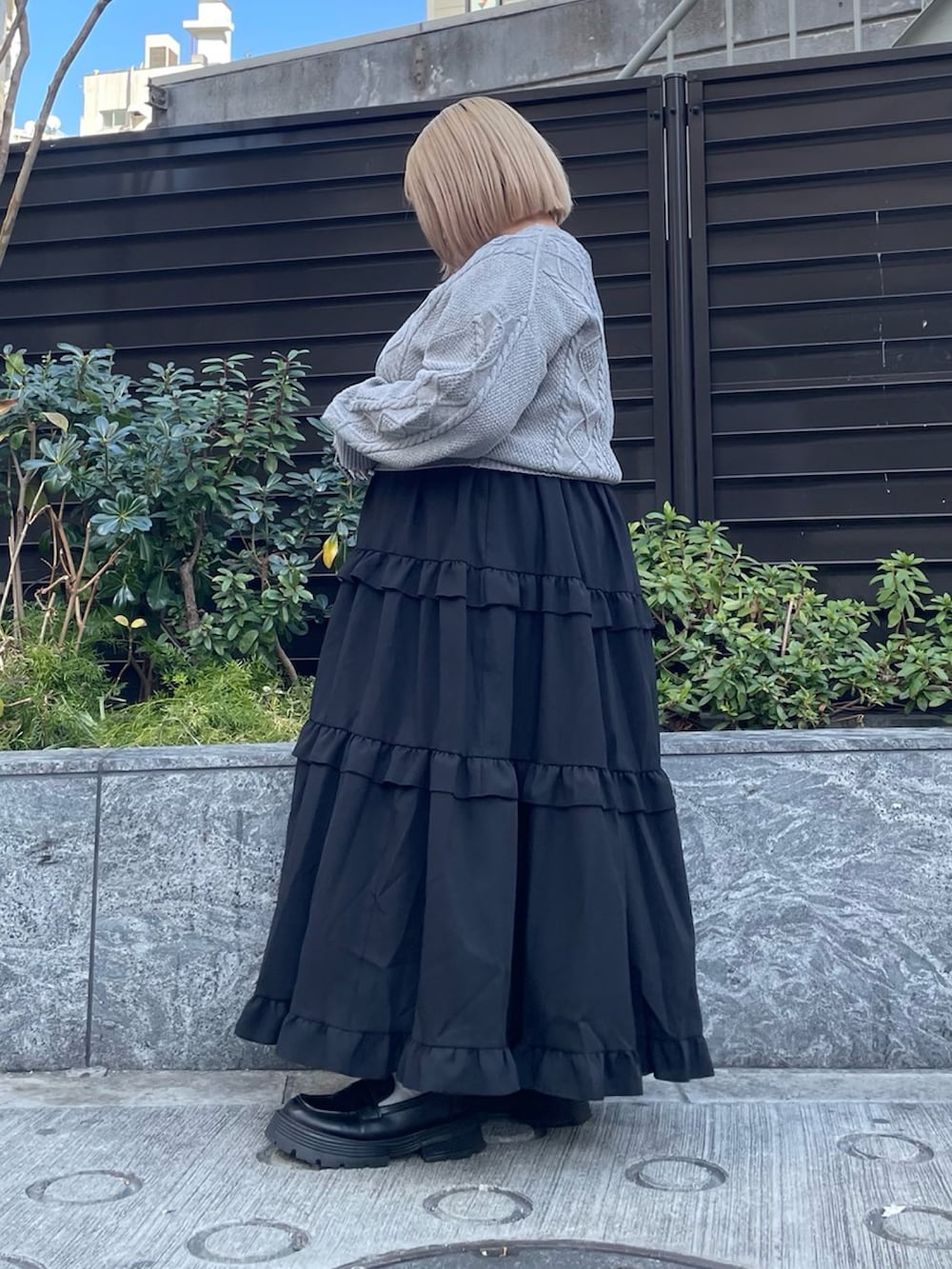 ブラック系のスカート、グレー系のニット/セーターを着用したレディースの冬コーディネートの3枚目の写真