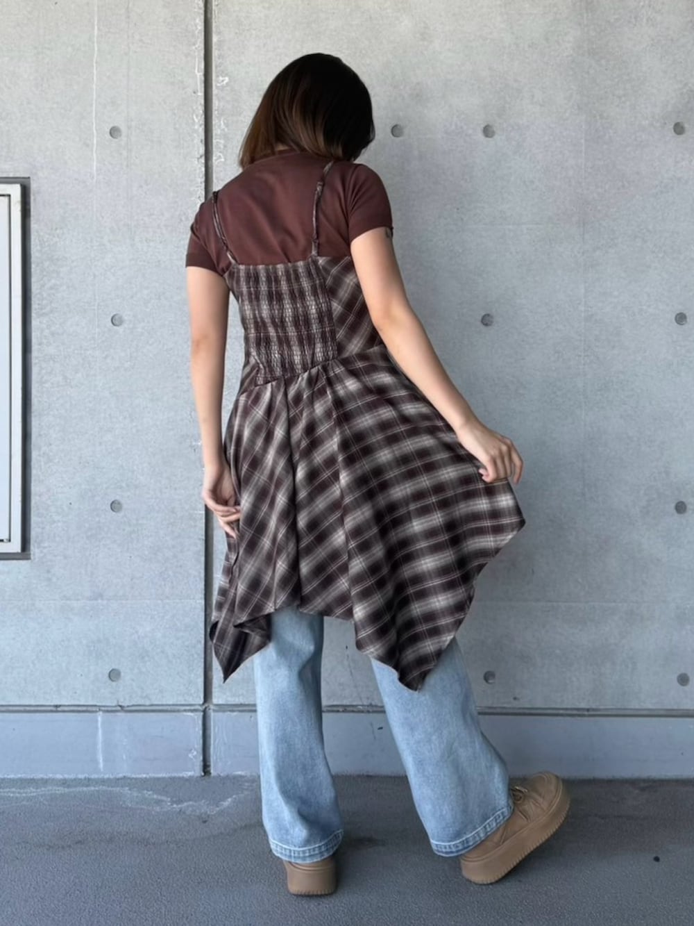 ブルー系のデニムパンツ、ブラウン系のワンピース、ブラウン系のニット/セーターを着用したレディースの春コーディネートの4枚目の写真