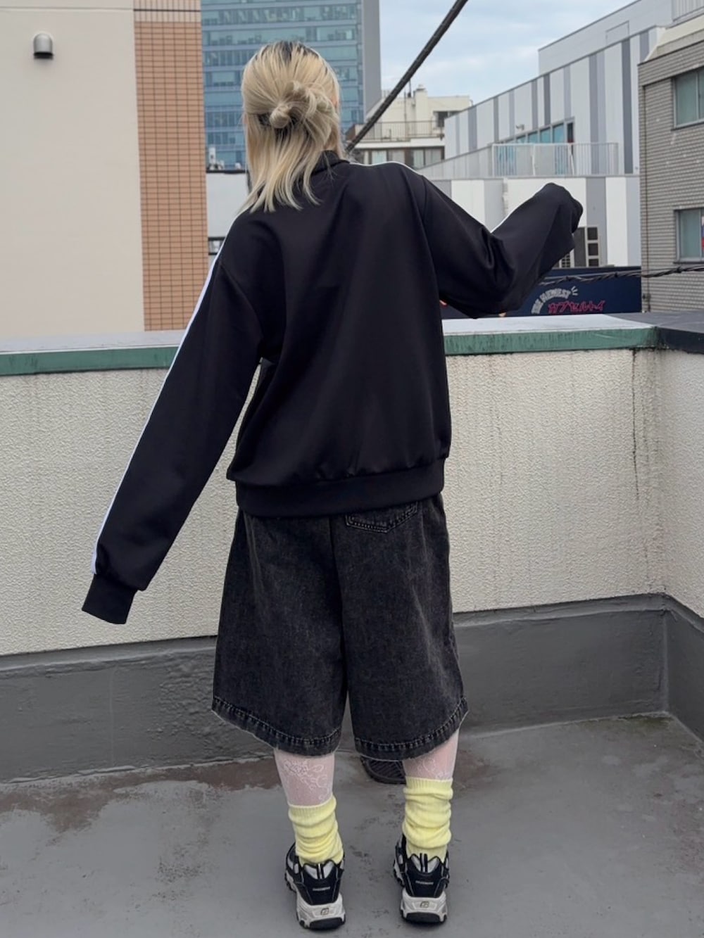ブラック系のジャージ、ブラック系のデニムパンツ、イエロー系のソックス/靴下を着用したレディースの秋コーディネートの5枚目の写真