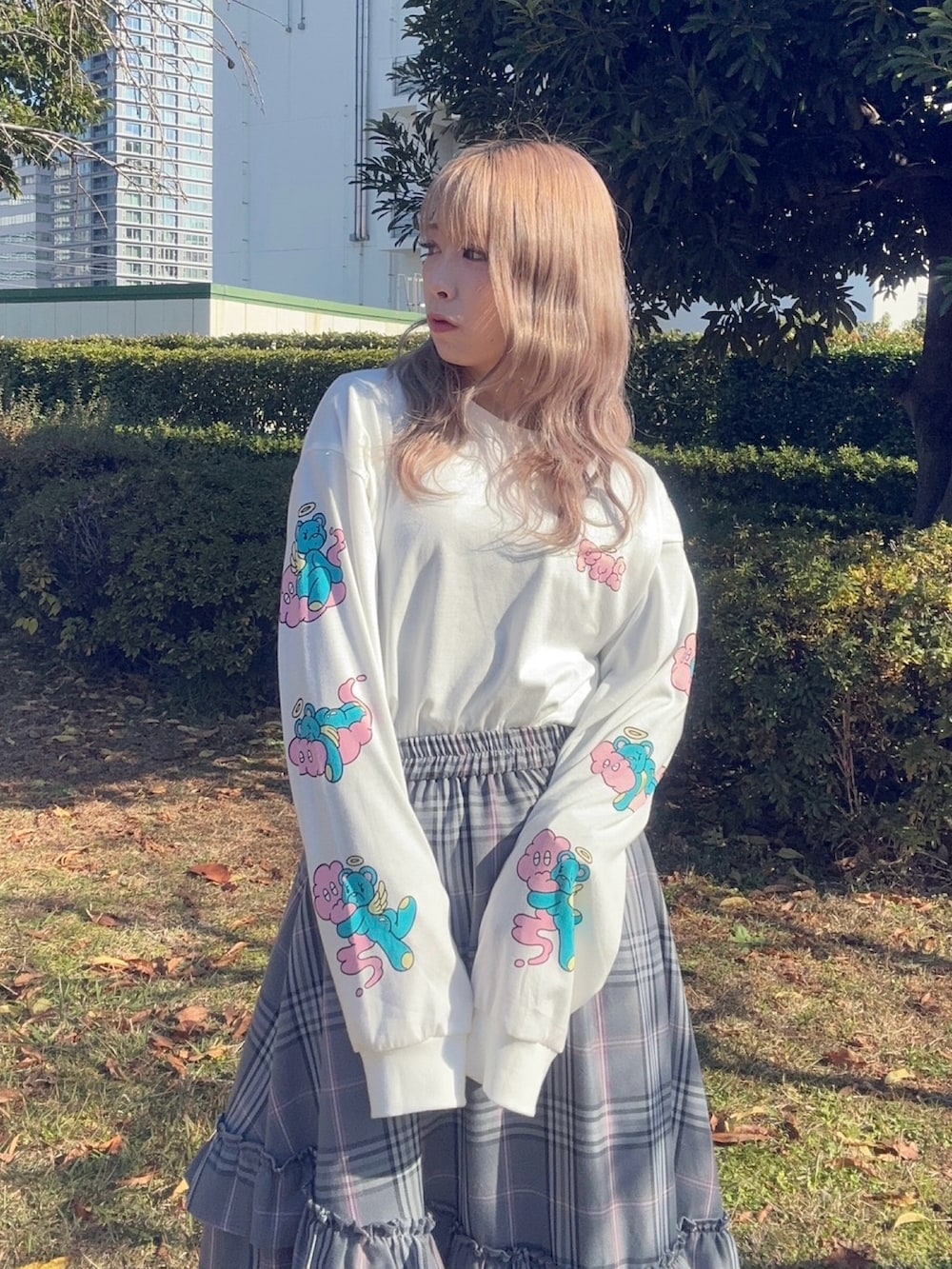 グレー系のスカート、ホワイト系のTシャツ/カットソー、ピンク系のニット/セーターを着用したレディースの秋コーディネートの4枚目の写真