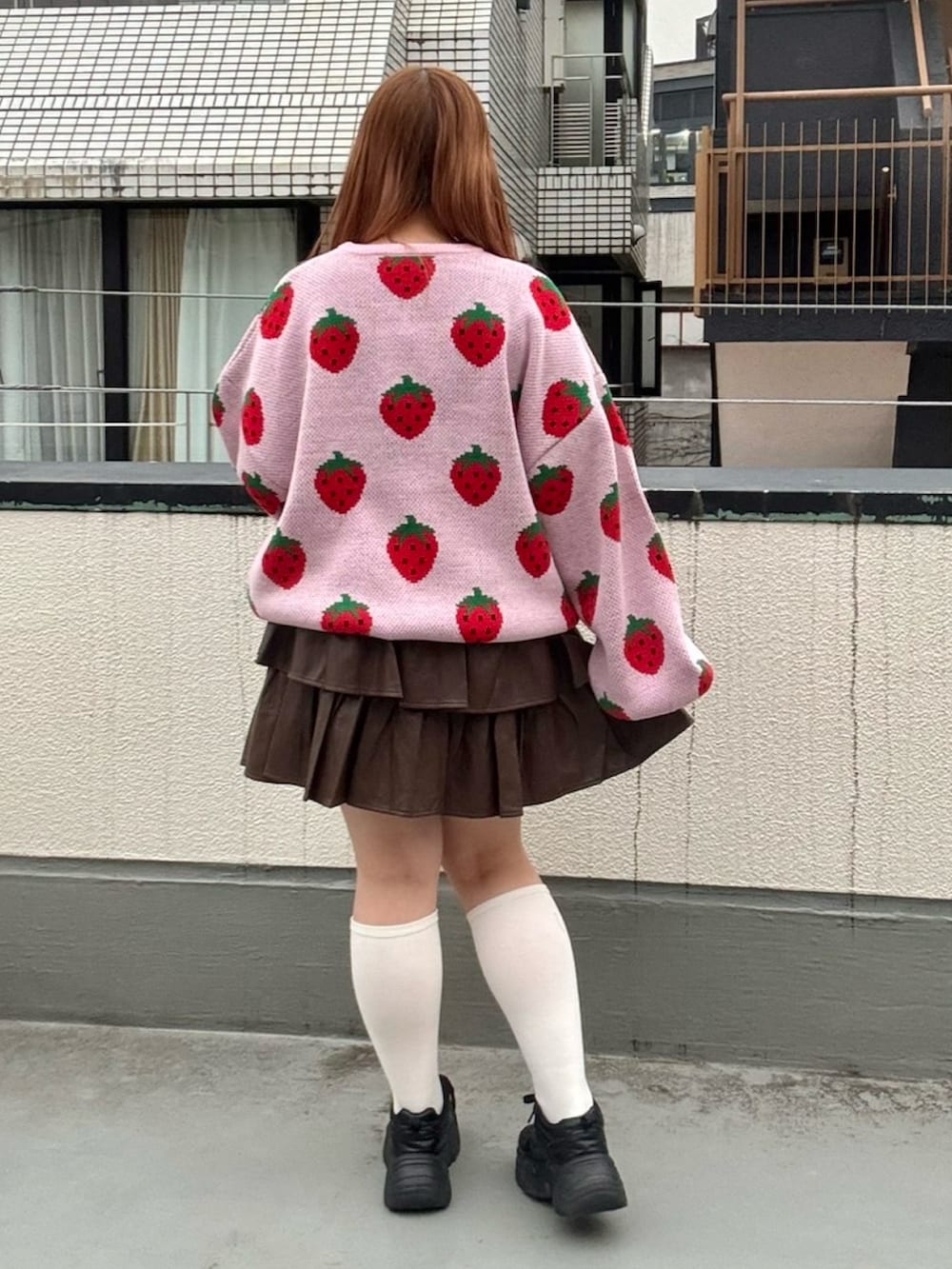 ブラウン系のスカート、ピンク系のニット/セーターを着用したレディースの秋コーディネートの3枚目の写真