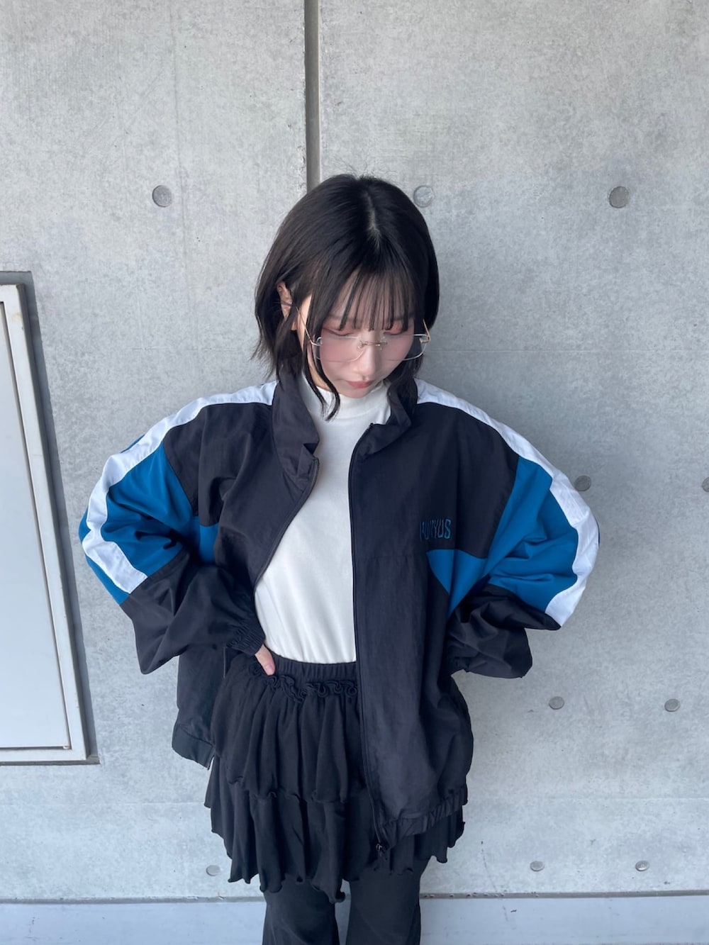 ブラック系のその他パンツ、ブラック系のナイロンジャケット、ホワイト系のTシャツ/カットソーを着用したレディースの春コーディネートの3枚目の写真