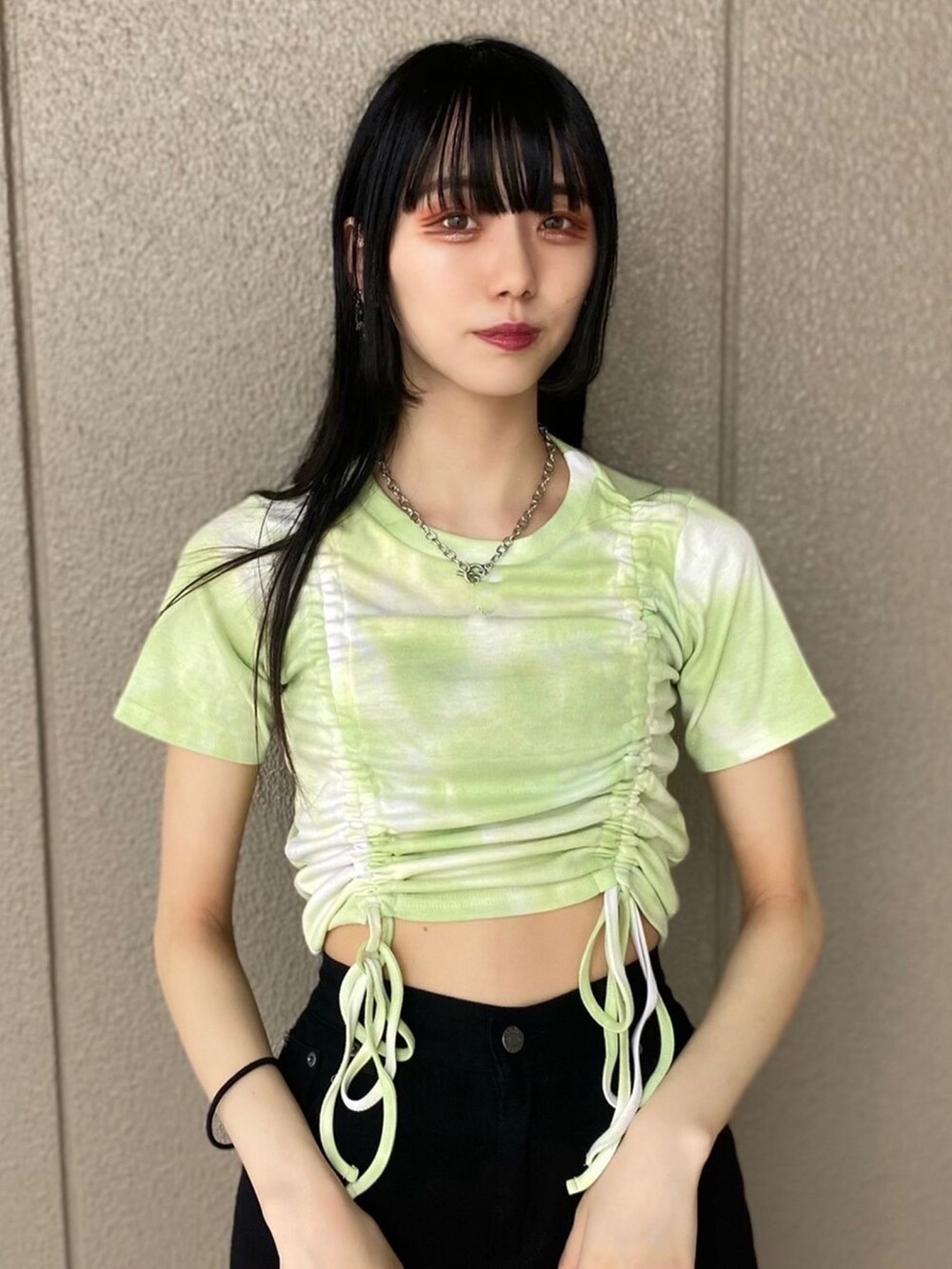 グリーン系のTシャツ/カットソー、ブラック系のデニムパンツ、ブラック系のスニーカーを着用したレディースの夏コーディネートの2枚目の写真