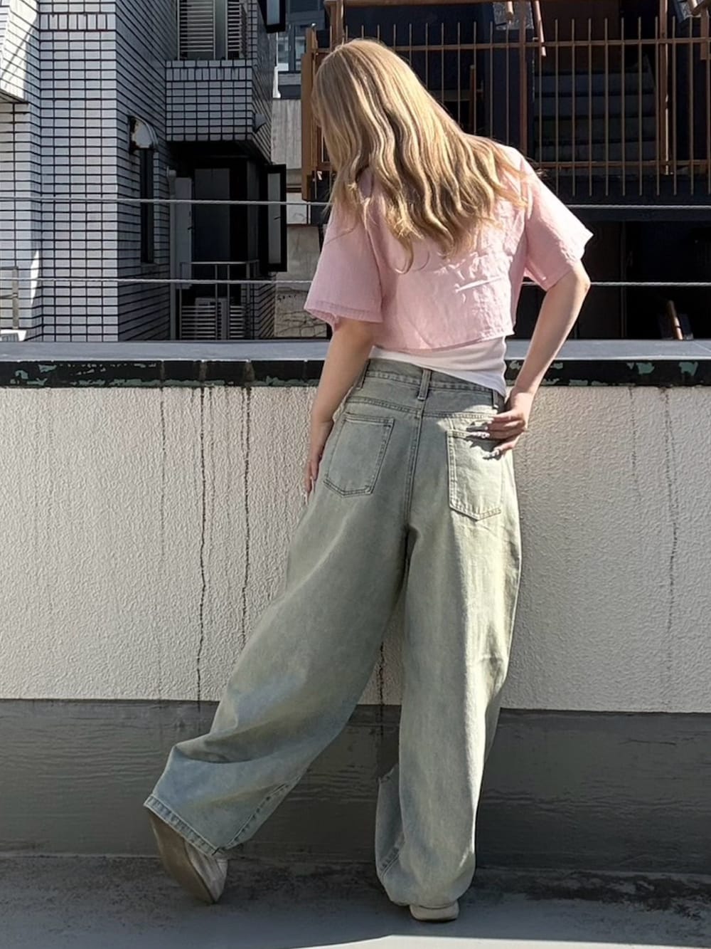 ブルー系のデニムパンツ、ピンク系のシャツ/ブラウス、ホワイト系のタンクトップを着用したレディースの夏コーディネートの3枚目の写真
