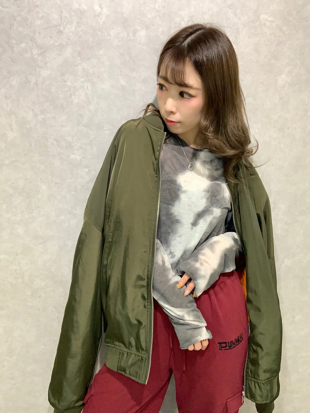ブラック系のTシャツ/カットソー、グリーン系のMA-1、レッド系のスウェットパンツを着用したレディースの秋コーディネートの3枚目の写真