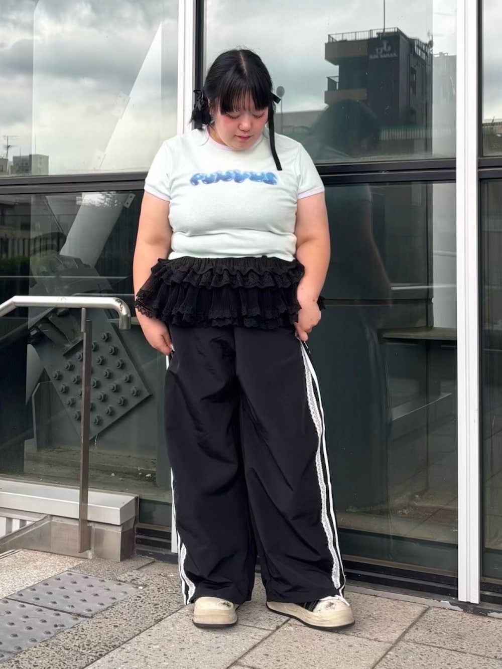 グリーン系のTシャツ/カットソー、ブラック系のスカート、ブラック系のその他パンツを着用したレディースの夏コーディネートの5枚目の写真