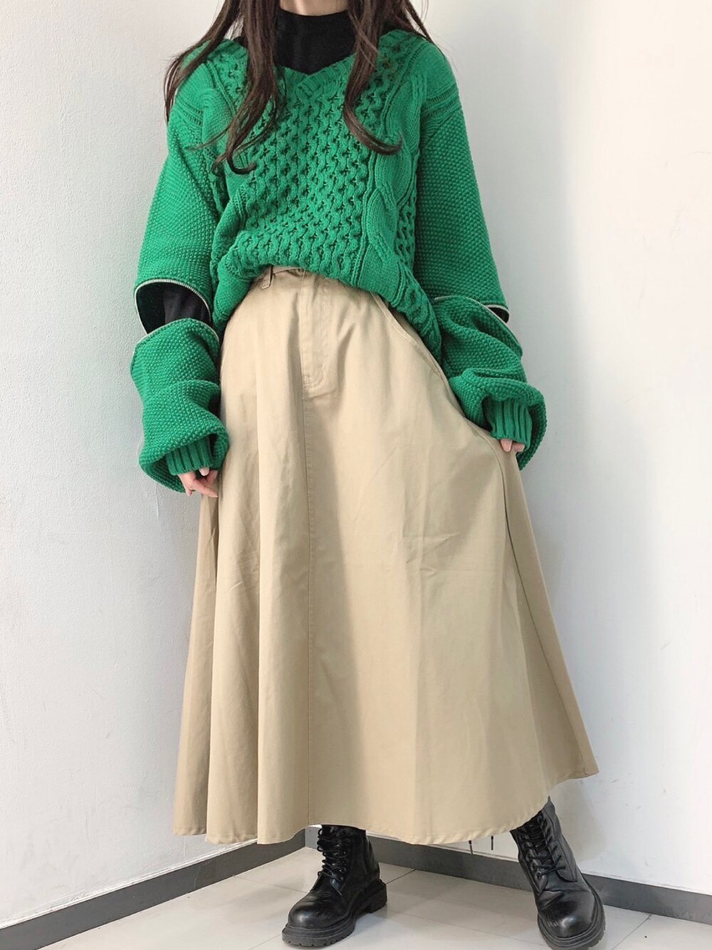 ブラック系のTシャツ/カットソー、グリーン系のニット/セーター、ベージュ系のスカートを着用したレディースの冬コーディネートの3枚目の写真