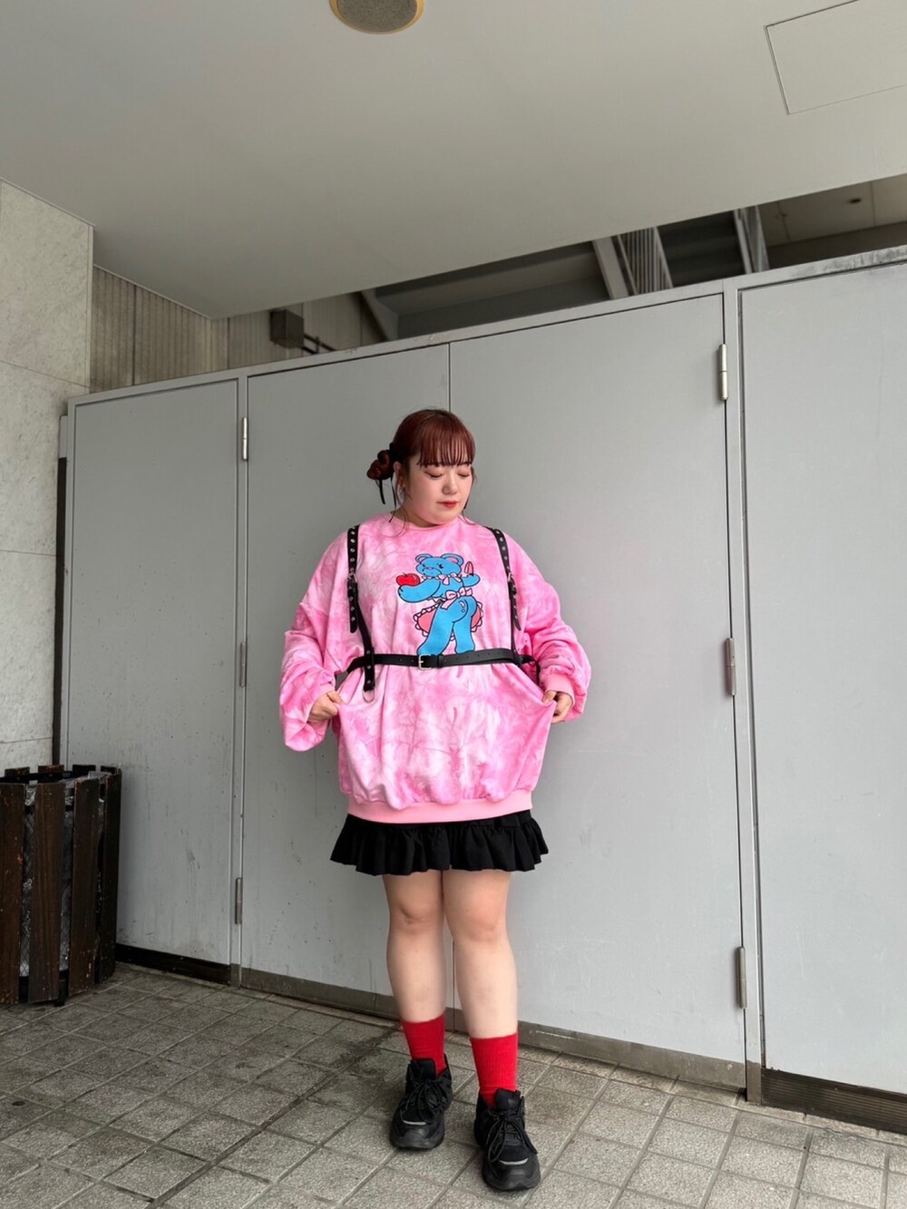 ピンク系のスウェット、ブラック系のスカート、ブラック系のベルトを着用したレディースの秋コーディネートの2枚目の写真